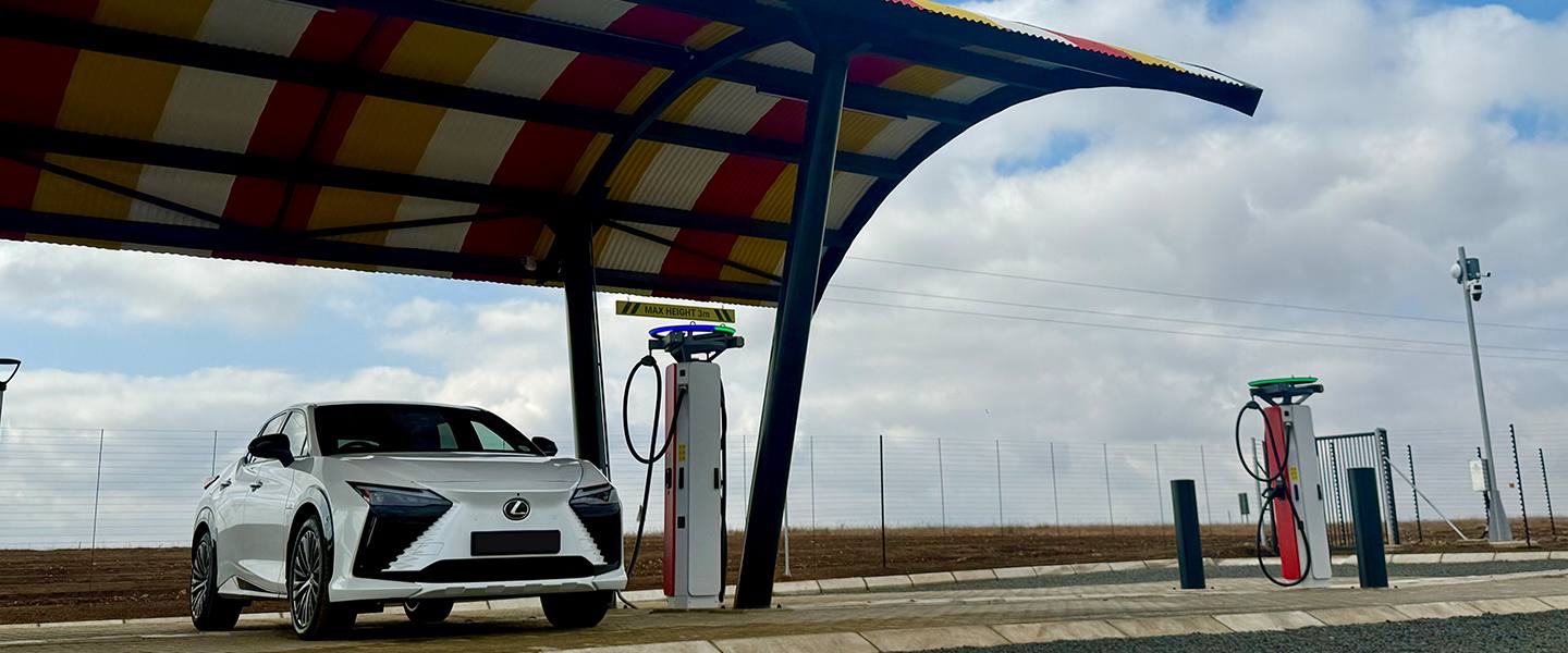 Front view of a white Lexus RZ between two rural EV chargers
