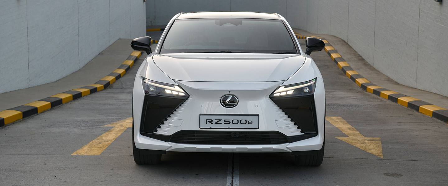 Front view of the white Lexus RZ 500e in a concrete driveway