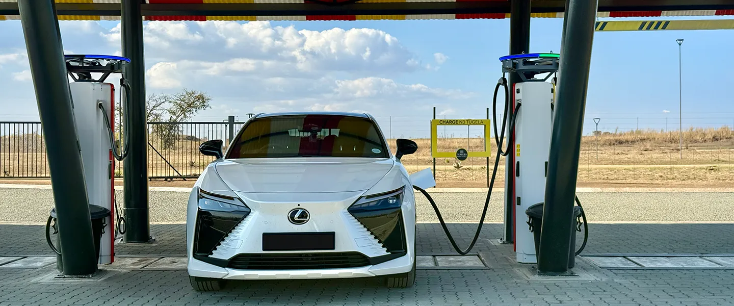 The white Lexus RZ connected to a public EV charger