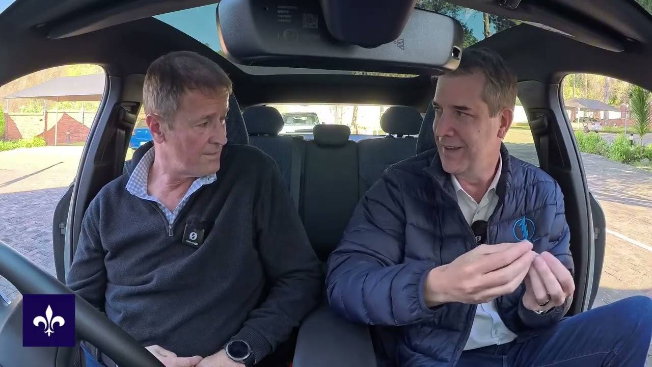 Jonathan Broekman and Greg Cress discussing electric cars inside a parked vehicle